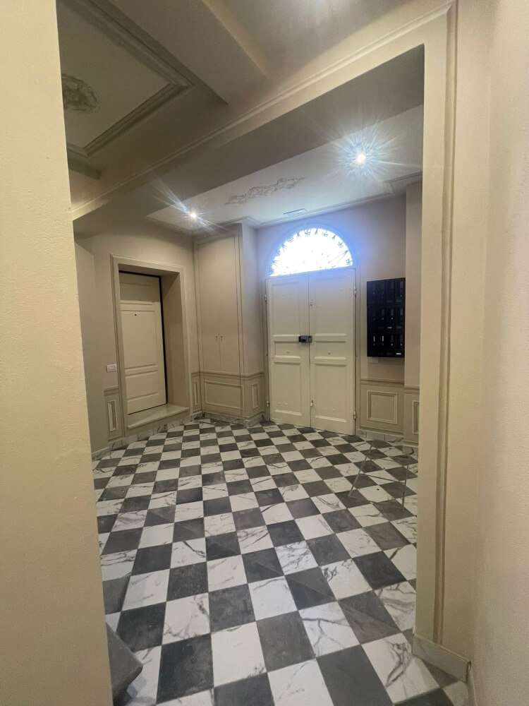 Ingresso di palazzo storico ristrutturato con affreschi e pavimenti in marmo, Pisa centro storico.